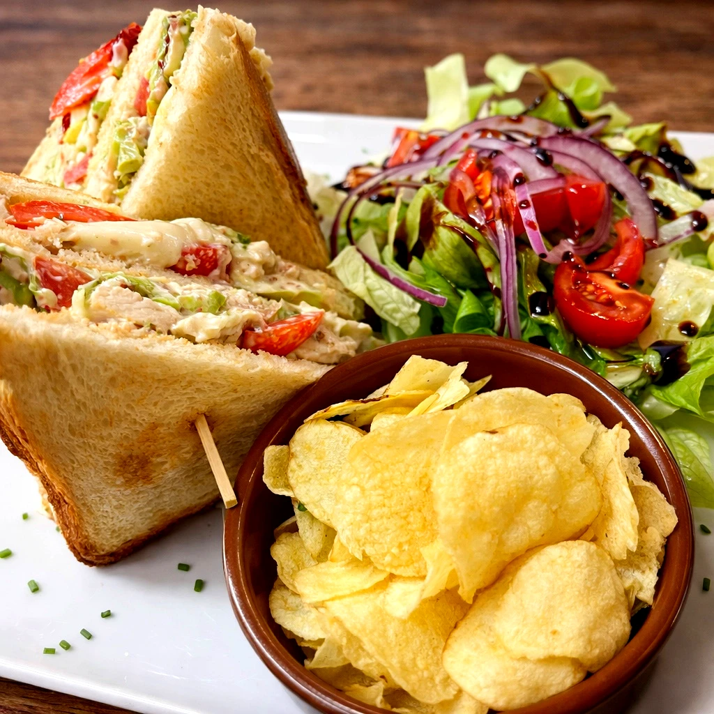 Club poulet au pain de mie avec blanc de poulet, salade, tomates, œufs et sauce maison, servi avec des chips au restaurant italien Pasta & Gusto à Ajaccio